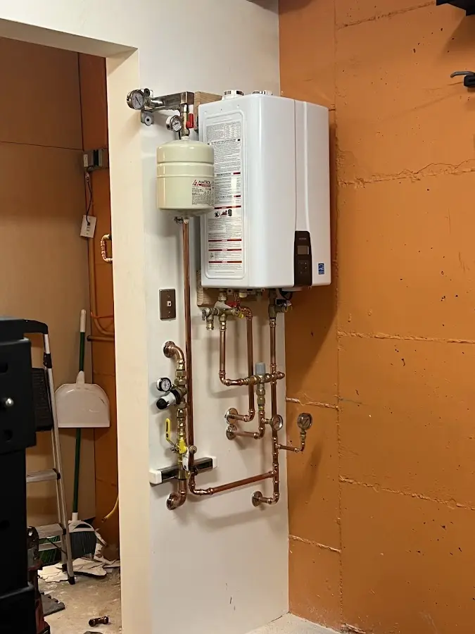 Plumbing technician inspecting water heater connections in Weston